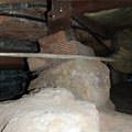A crawl space support consisting of a rock and wood shimming in a Fishers home
