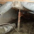 Rusty steel crawl space jack post supports in a structure in Lafayette.
