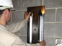 Mounting a foundation wall plate for an earth anchor installation in Greenwood.