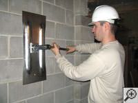 Attempting to straighten a bowed foundation wall by straightening a wall anchor system in a Noblesville home.