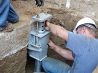 Foundation repair contractors installing the foundation bracket in Fort Wayne.