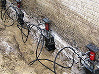 Using foundation push piers to lift a foundation during a repair in Kokomo.